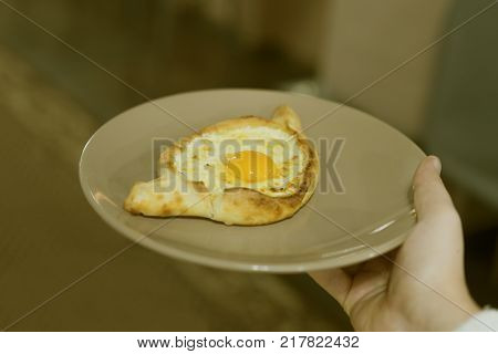 Adjarian khachapuri with egg, on the plate. toned
