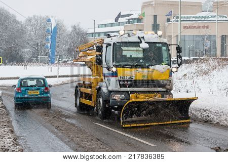 Hemel Hempstead UK - December 10 2017: Snow plough truck clears the snow from the road and spreading salt during snow storm