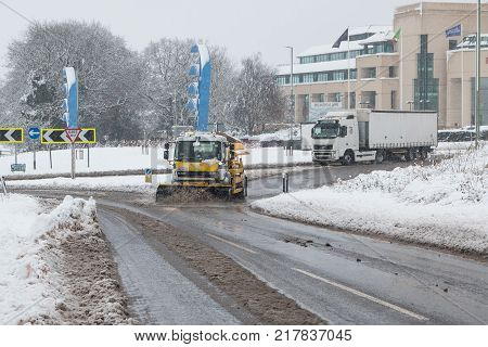 Hemel Hempstead, UK - December 10 2017: Snow plough truck clears the snow from the road and spreading salt during snow storm