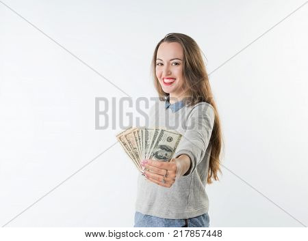 Cheerful pretty young woman holding dollars cash and happy smiling to the camera isolated on white background