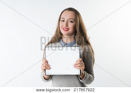 Business concept - Young woman with an empty plate or frame isolated on white background. Free Copyspace