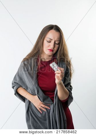 Woman in abdominal pain or stomachache holds pills or drugs Isolated on a white background with copyspace