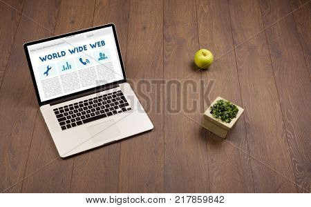 Laptop computer on wooden desk with office suplies