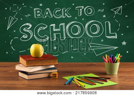 Back to school concepty with writing on blackboard and desk, apple, books, items