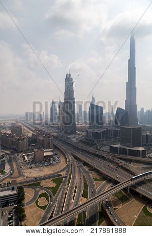DUBAI UAE - JANUARY 23 2016: Vertical Burj Khalifa tallest building in the world 829.8 m. Metro train on the Red line Dubai Burj Khalifa aerial view United Arab Emirates