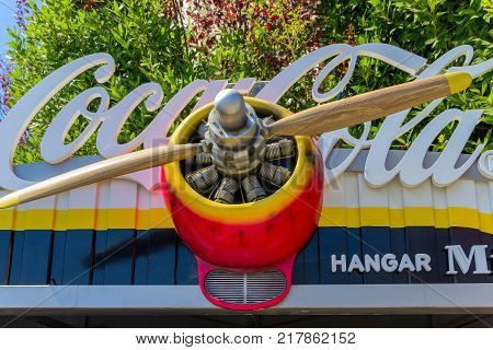 BARCELONA SPAIN - AUGUST 26 2012: Coca - Cola sign on the top roof and vintage wood aircraft propeller systems Parc d'Atraccions del Tibidabo Barcelona.