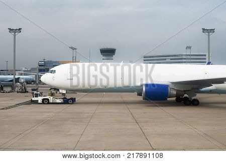 Tug Pushback Tractor With Aircraft On The Runway In Airport.