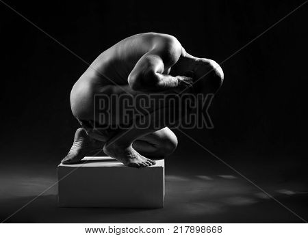 studio portrait of athletic man. Body skulptur. Monochrome photo.
