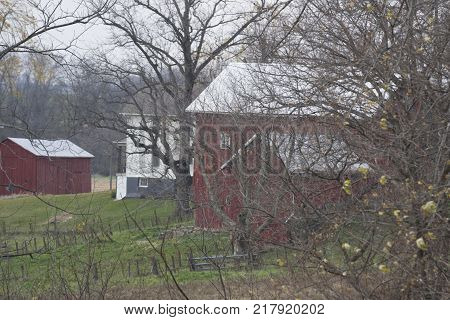 This is a farm that is revealed in the fall when the leaves are off the trrees.