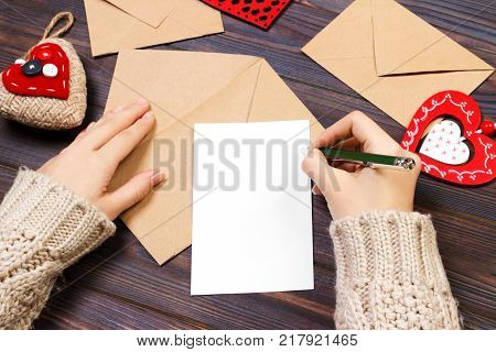 Woman writing love letter or romantic poem for Valentines day top view of female hands. Valentine day concept with copyspace.