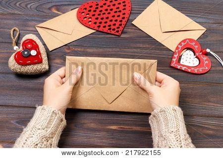 Woman preparing handmade envelope for wrapping on Valentine's Day. Valentine day concept with copyspace.