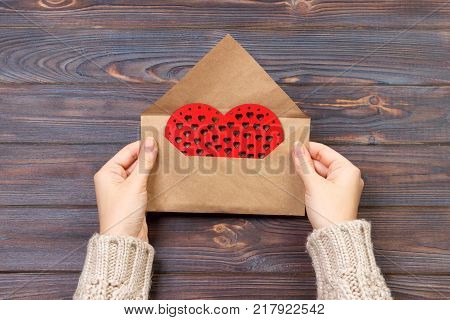 Woman preparing handmade envelope for wrapping on Valentine's Day. Valentine day concept with copyspace.