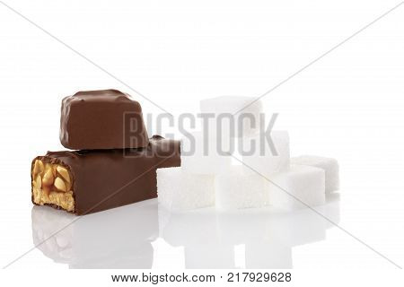 Chocolate bar and sugar cubes isolated on white background. Unhealhy eating sugar and carbs.
