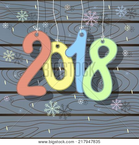 Christmas card 2018 New Year with hanging bright colored figures and falling snowflakes on gray blue wooden background.