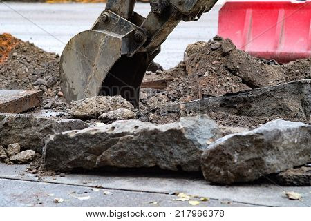 excavator removes road asphalt on the roadway