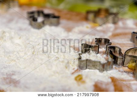 Baking christmas gingerbread with white flour on the wooden table