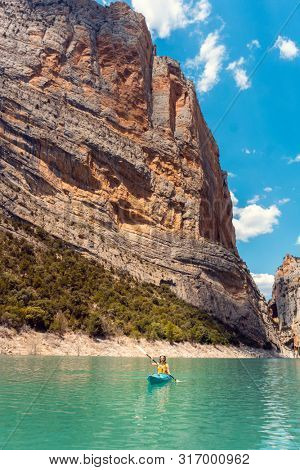 Woman on a kayak in the Pyrenees mountains in Catalonia on the waters of the Mont Rebei Gorge