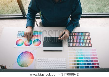 Freelance Creative Designers Working On Desk Using Digital Graphic Tablet And Drawing With Pen In Mo