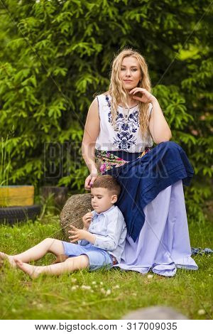 Portrait Of Happy Caucasian Mother With Her Little Kid. Posing With Basket Full Of Bread Rings Outdo