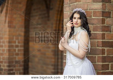Closeup Portrait Of Romantic Sensual Caucasian Bride With Crown And Necklace Posing Against Old Bric