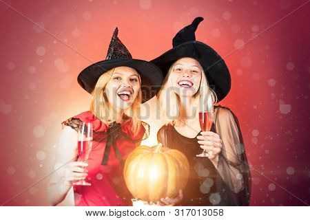 Halloween Party. Two Happy Young Women In Black And Red Dresses, Costumes Witches Halloween On Party