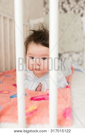 Baby In The Crib. Funny Baby In A White Canopy Bed. Childrens Room Interior And Bedding For Children