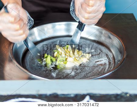 Making Rolled Ice Cream. Man Hands Making Kiwi And Banana Thay Style Natural Ice Cream