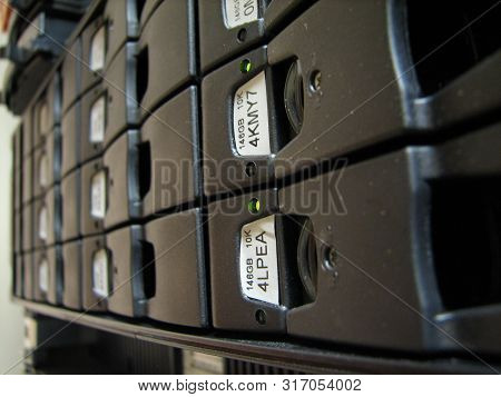 Servers Stack With Disc Drives In A Rack And Glowing Lights