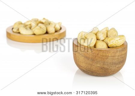 Lot Of Whole Unsalted Beige Cashew On Round Bamboo Coaster In Tiny Wooden Bowl Isolated On White Bac