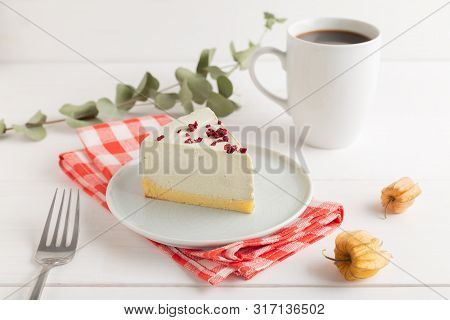 Piece Of Cheesecake On Gray Plate On Kitchen Spatula And Cup Of Coffee On Background