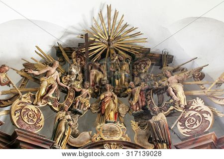 CAZMA, CROATIA - SEPTEMBER 26, 2011: Holy Trinity, Virgin Mary, Saints and Angels, statues on the main altar in the Church of Saint Mary Magdalene in Cazma, Croatia