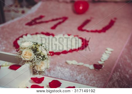 A Heart Made Of Petals On The Beds. Red Petals. Close Up Of White Flowers In The Bed . White Wedding