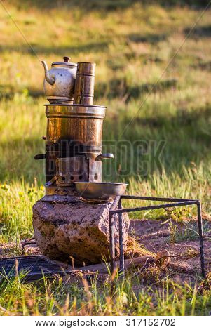 Turkish Samovar Outdoor. Preparing Tea Outside On The Nature On The Double Pot On The Fire.
