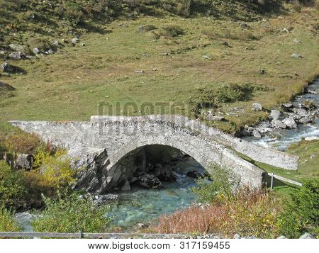 Stonebridge Over A Mountain River On A Sunny Summer Day