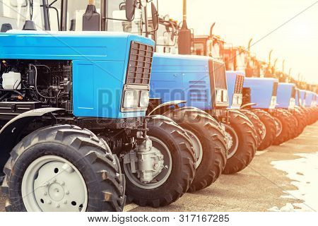 Many Different Tractors Standing In Row At Agricultural Fair For Sale Outdoors.equipment For Agricul