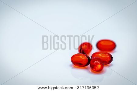 Red Soft Gel Capsule Pills Isolated On White Background. Pile Of Red Soft Gelatin Capsule. Vitamins 