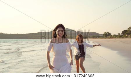 Young Asian Lesbian Couple Running On Beach. Beautiful Women Friends Happy Relax Having Fun On Beach