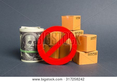 The Prohibition Sign No Blocks A Bundle Of Dollars Money And Cardboard Boxes. Embargo, Trade Wars. R