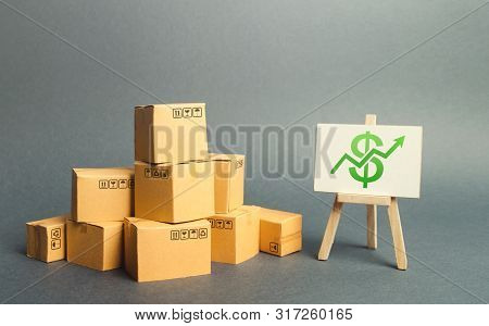 A Pile Of Cardboard Boxes And A Stand With Green Arrow Up. Increasing Consumer Demand. Rate Growth O