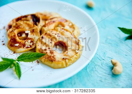Grilled Apples With Cinamon On White Plate On Blue Background.