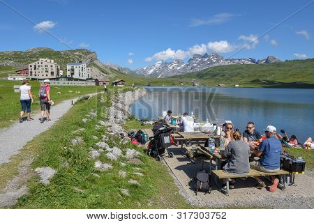 People Hiking And Eating At Melchsee-frutt On The Swiss Alps
