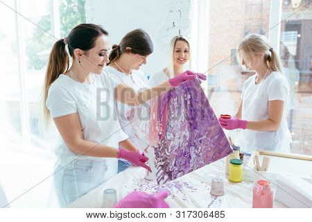 Group Of Female Creating And Slowly Whirling Canvas With Liquid Acrylics Abstract Painting In Art Th
