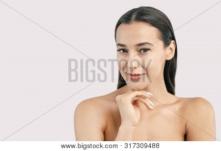 Portrait Of Skittish Young Brunette Girl With Naked Shoulders And Hand Under Chin Isolated White Bac