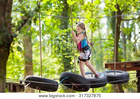 Child In Adventure Park. Kids Climbing Rope Trail.