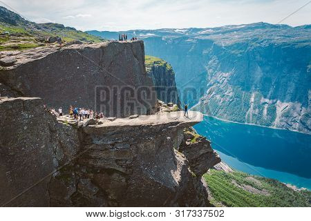 July 26, 2019. Norway Tourist Route On The Trolltunga. People Tourists Go Hiking In The Mountains Of