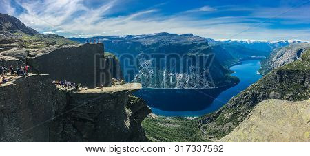 July 26, 2019. Norway Tourist Route On The Trolltunga. People Tourists Go Hiking In The Mountains Of