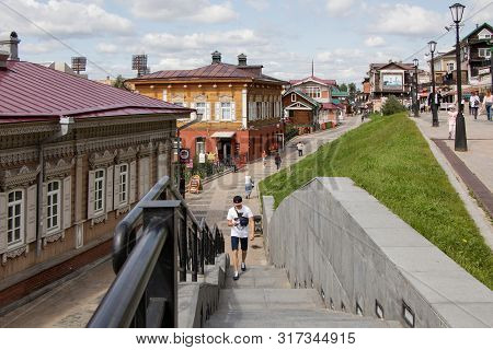 Irkutsk, Russia - August 12, 2019: People Walk Around A Tourist Place - The 130th Quarter. In The Fo