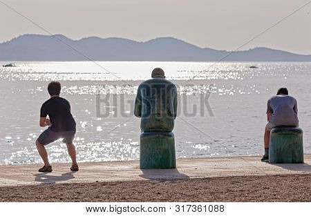 Zadar, Croatia - April 29, 2018: People Chilling By The Spiridon Brusina Monument At Promenade Obala