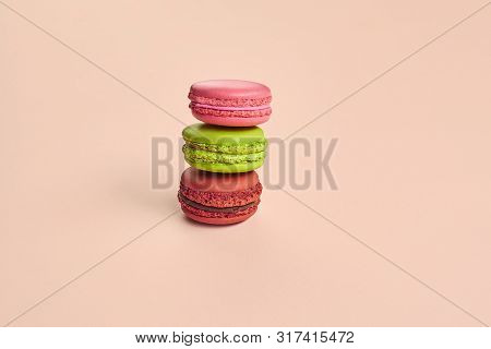 Colored Macaron Or Macaroon, Sweet Meringue-based Confection On Pink Background. Close-up, Copy Spac
