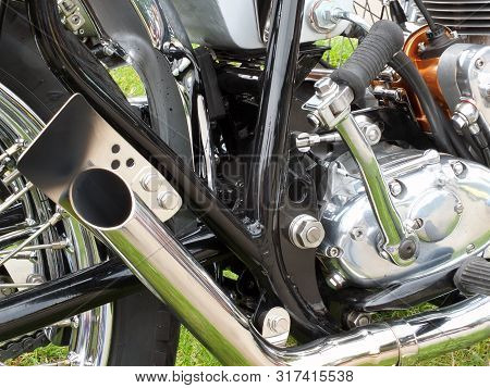 Close Up Of The Engine And Chrome Exhaust Pipe Of A Vintages Custom 1970s Scrambler Type Motorcycle